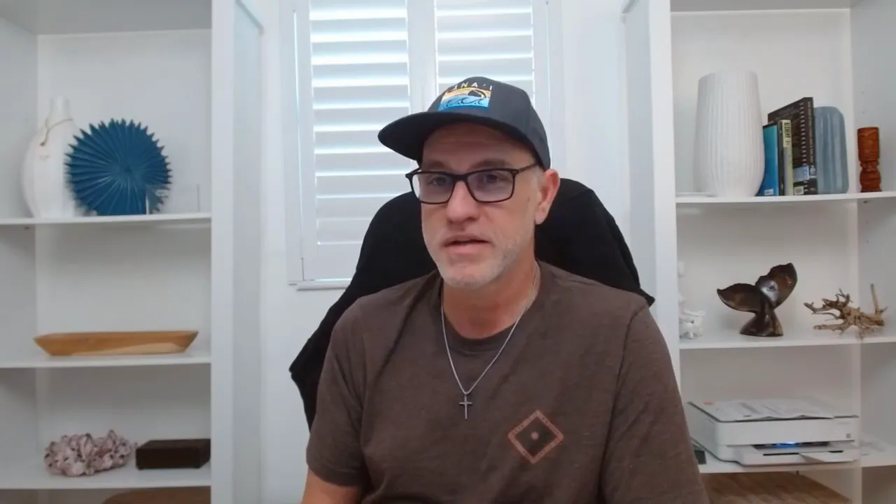 Speaker in a purple acoustic booth wearing white earbuds looking directly at the camera